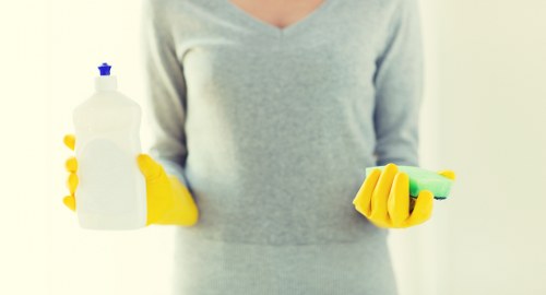 Cleaner wearing gloves and mask as part of PPE procedures